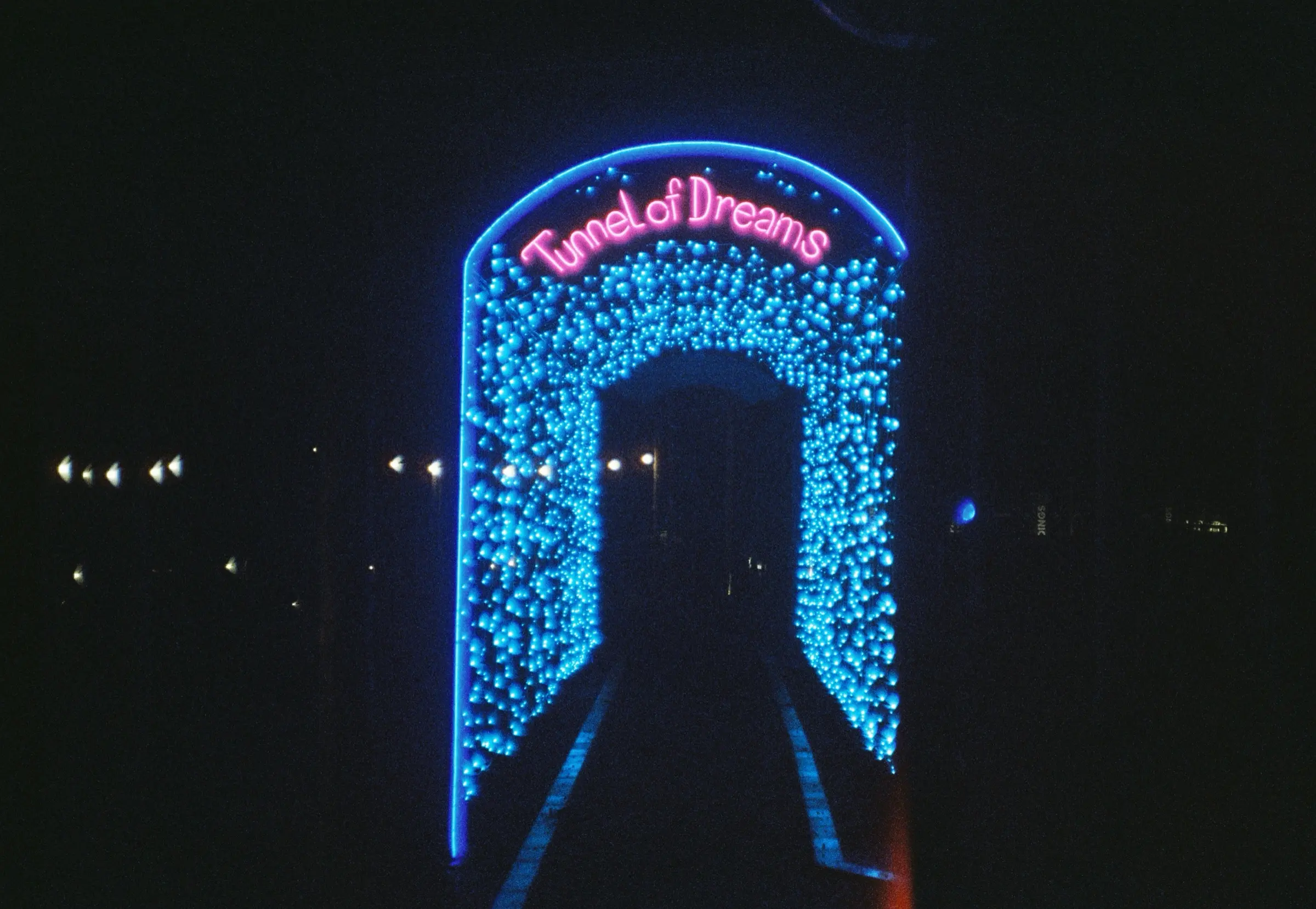Neon blue Tunnel of Dreams arch at night